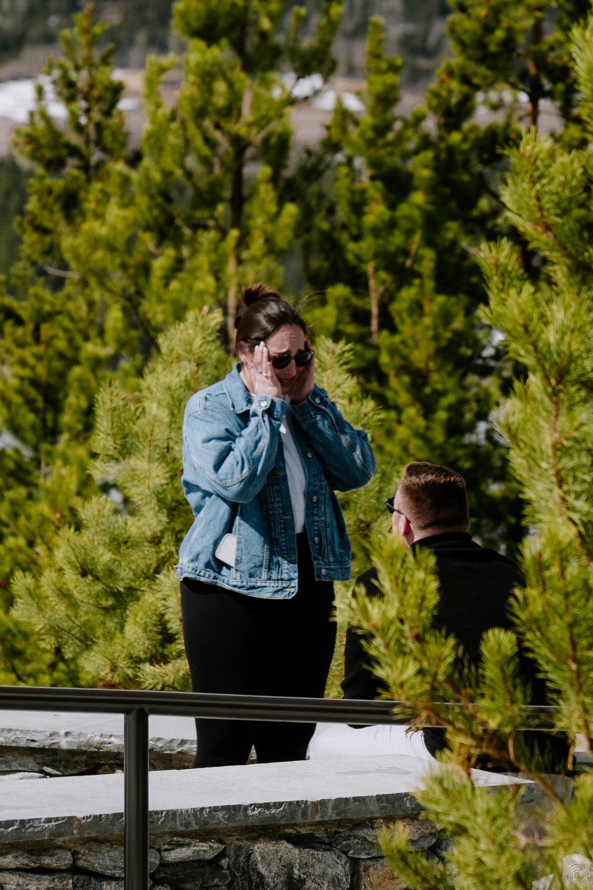 Woman reacting with tears of joy during surprise mountain proposal
